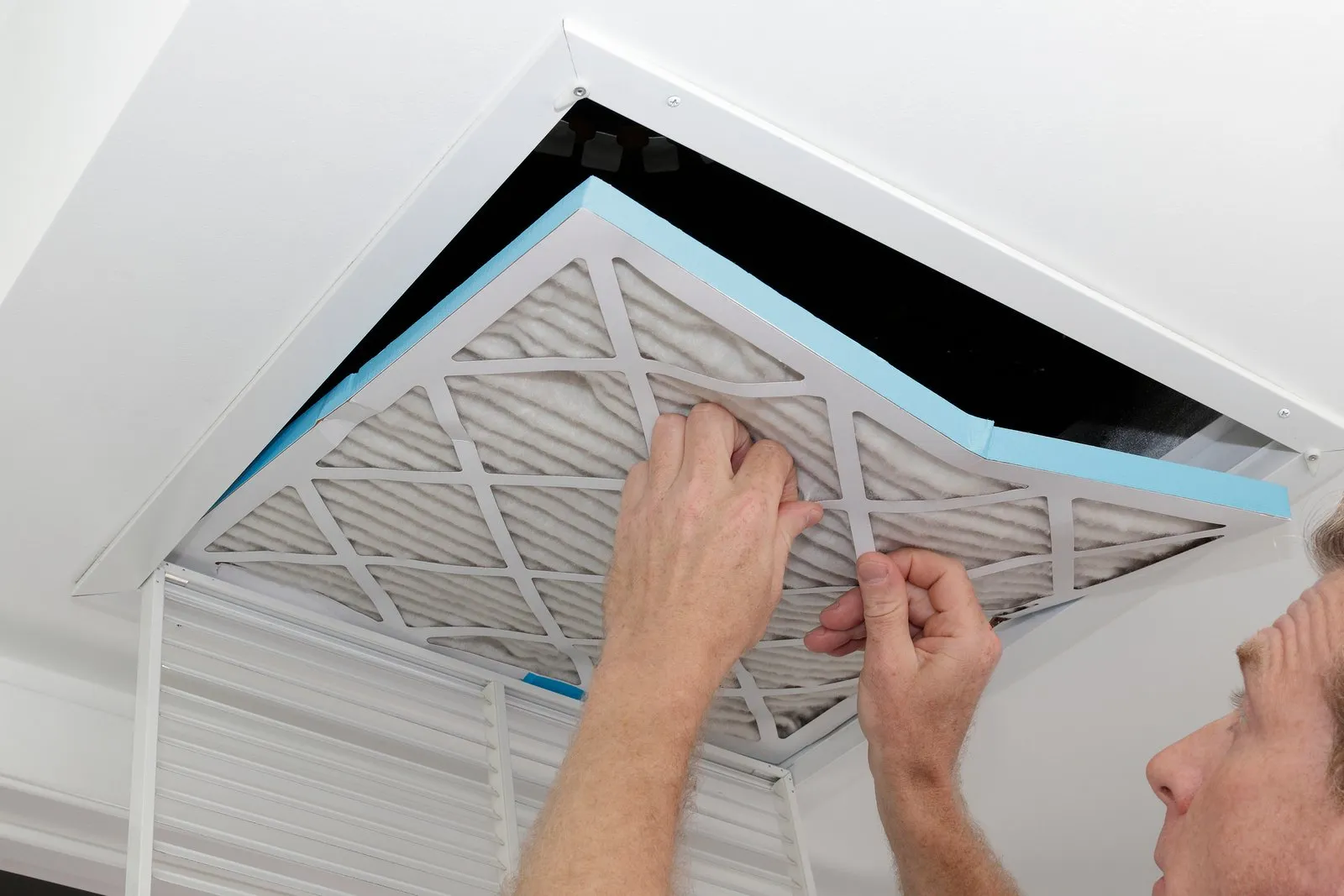 Technician cleaning an air duct vent in a Louisville home